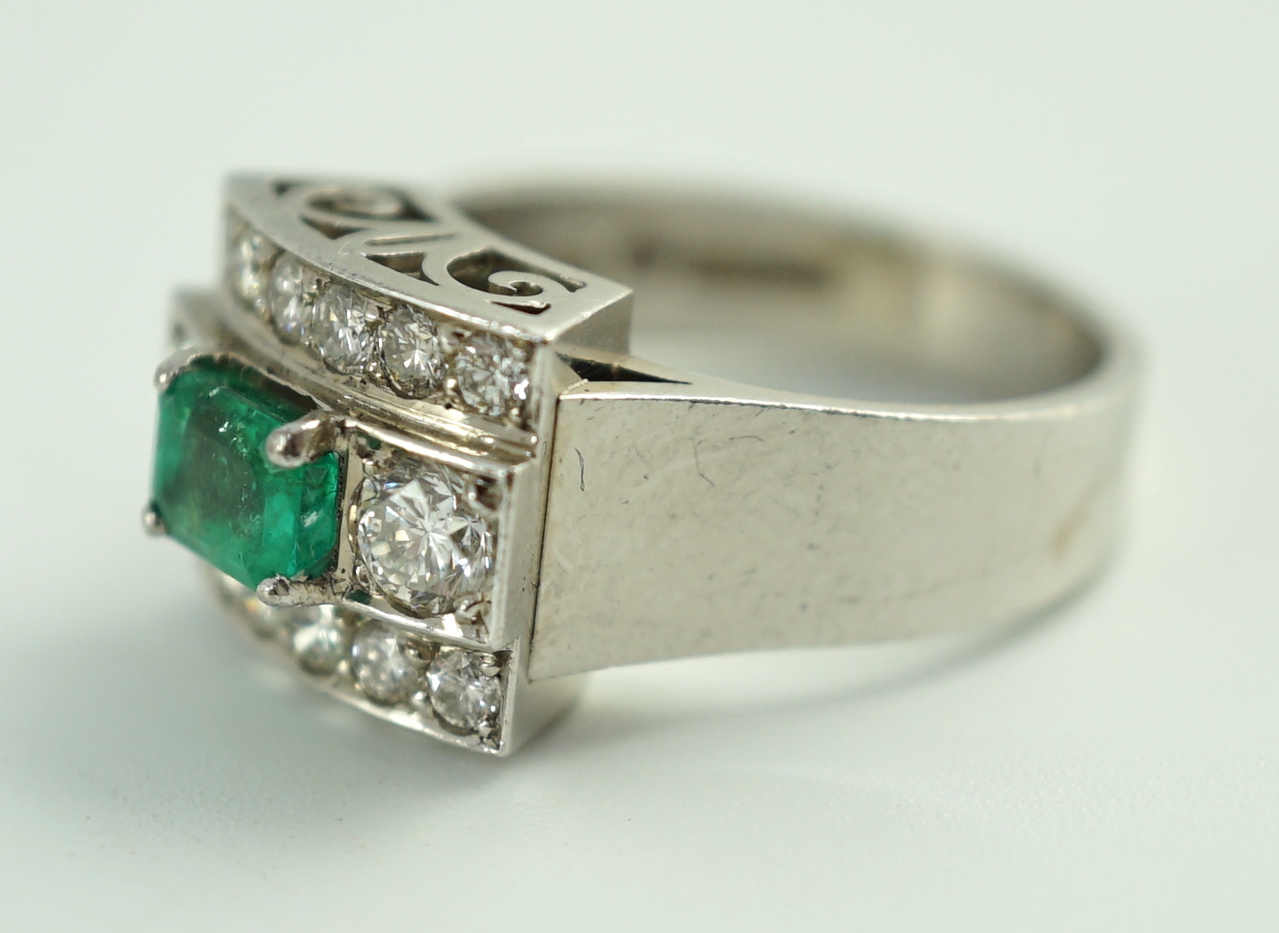 A Swedish 18k gold, single stone emerald and fourteen stone diamond set three row cluster ring